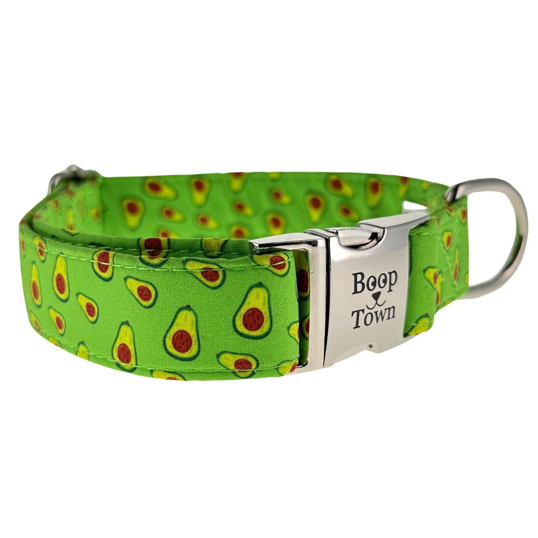 A green dog collar with avocado patterns and silver metal buckle and d-ring